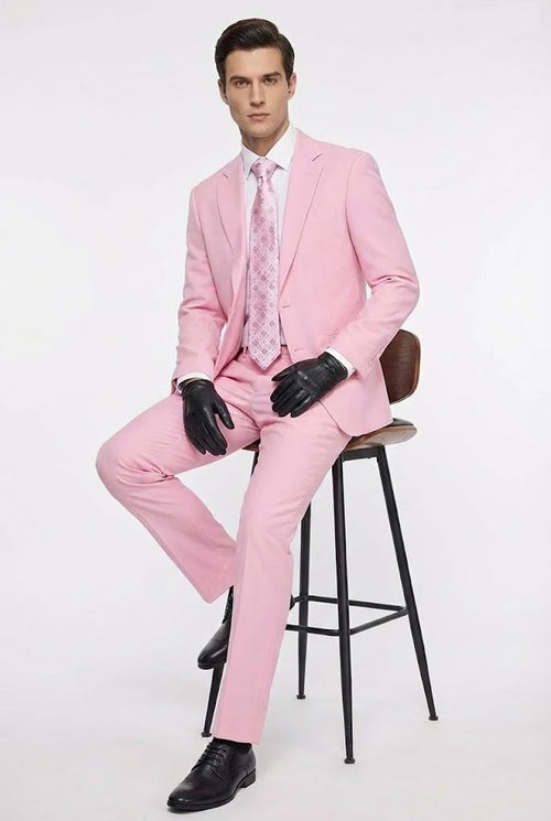 Men's pink two-piece suit with a classic fit jacket (notch lapel, single-button) and tailored pants. Includes a light shirt, patterned tie, black gloves, and dress shoes. Lightweight fabric.
