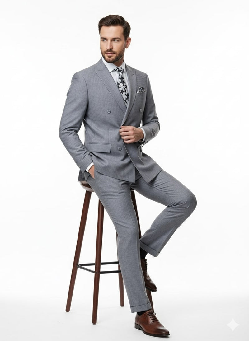 Men's slim fit suit in light gray with shadow stripes. Double-breasted jacket, matching trousers, and a fine woven fabric. Styled with a patterned tie and pocket square for a tailored look.
