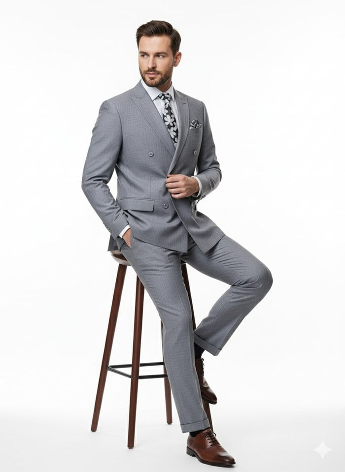 Men's slim fit suit in light gray with shadow stripes. Double-breasted jacket, matching trousers, and a fine woven fabric. Styled with a patterned tie and pocket square for a tailored look.
