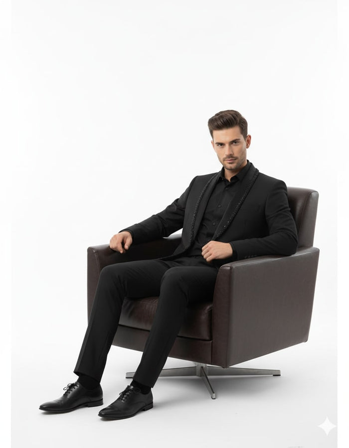 Men's black designer blazer. Fitted silhouette, sleek fabric. Beaded lapel, structured shoulders, single-button closure, and integrated front pockets. Classic, formal design.

