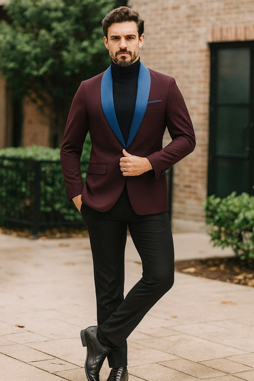 Men's burgundy tuxedo jacket with a structured fit. Features a blue satin shawl lapel, single-button closure, and chest pocket. Modern tailored design.

