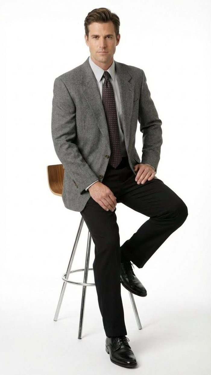 Men's charcoal grey blazer. Structured silhouette with textured fabric, notched lapels, two front flap pockets, and a single-button closure. Tailored fit.
