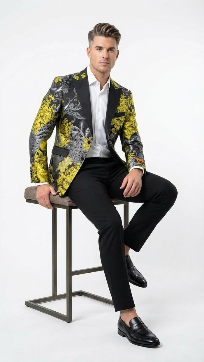 Yellow men's tuxedo with black & gold floral pattern. Structured blazer with black shawl collar and pockets. Floral design features yellow blooms, black & grey detailing.
