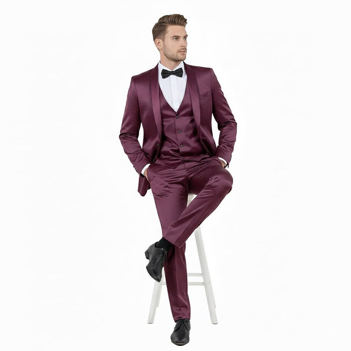 Burgundy men's slim fit tuxedo with shiny satin finish. Shawl lapel, three-piece suit: jacket, vest, and trousers.
