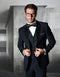 Navy blue, modern fit, 2-button wool tuxedo. Structured jacket with shawl collar, matching vest. Includes white dress shirt & black bow tie. Classic & tailored ensemble.