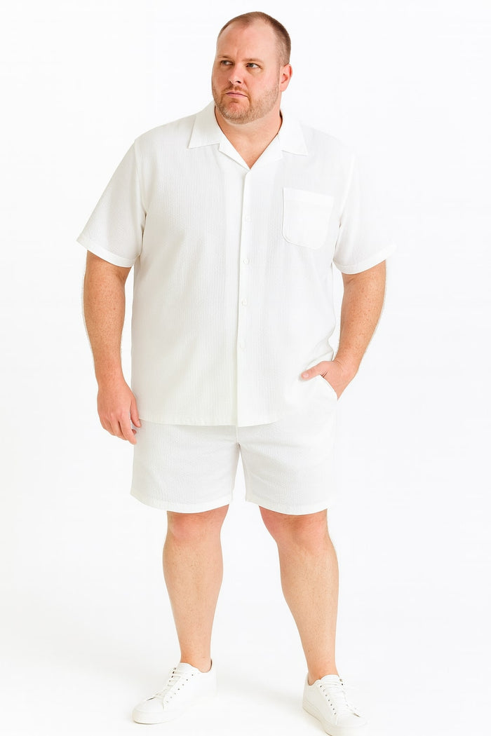 Men's short set: White seersucker shirt & shorts. Shirt: collared, short sleeves, pocket. Shorts: relaxed fit, elastic waist, hemmed cuffs. Lightweight, textured fabric.
