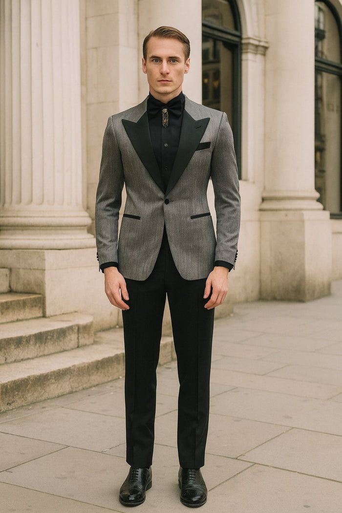 Silver metallic tuxedo suit with black satin peak lapel. Fitted jacket, long sleeves, single-button closure. Tailored black trousers. Includes black shirt and bow tie.
