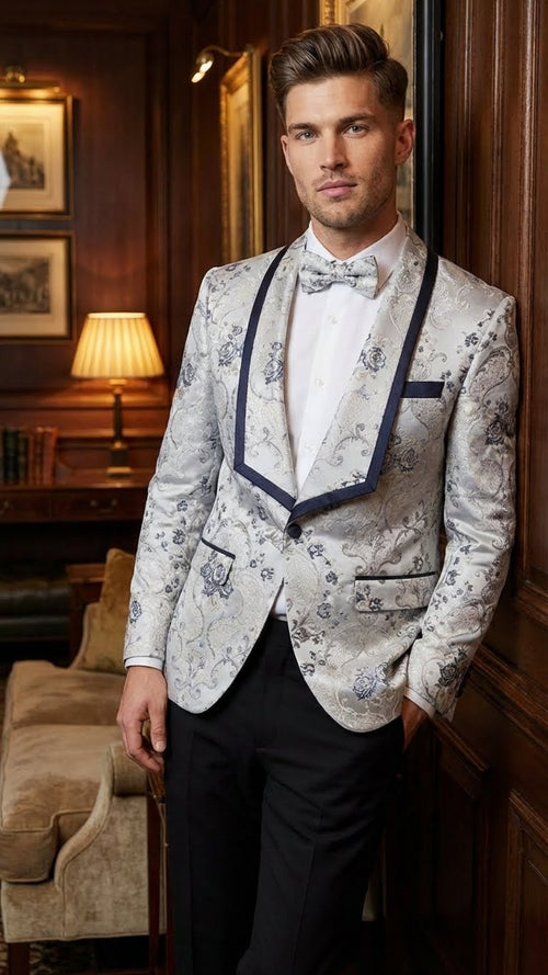 Men's white & navy floral jacquard blazer. Features contrast shawl lapel, intricate patterns, tailored fit, & navy pocket detail. Structured lapels for a stylish look.
