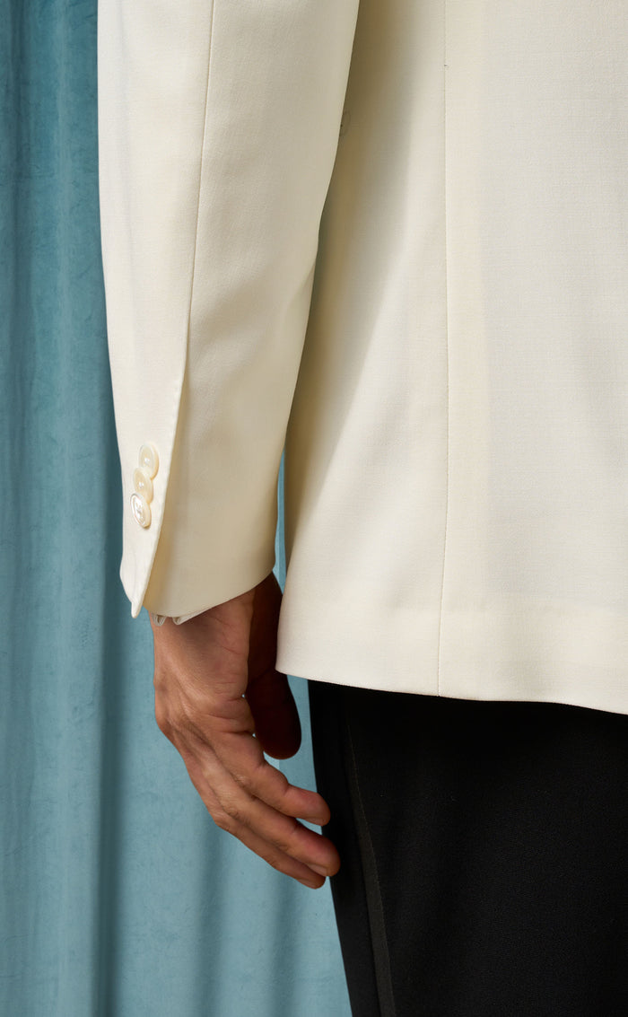 Men's ivory dinner jacket: Smooth, tailored fit in lightweight fabric. Cream color, single-button closure, three cuff buttons. Notch lapel, clean lines, back vent.
