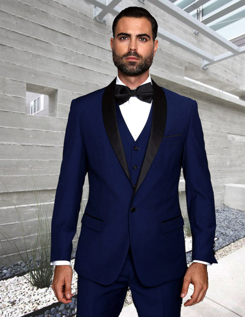 Sapphire blue men's modern fit wool tuxedo. Features a one-button closure and shawl lapel. Includes a matching vest, white shirt, and black bow tie. Tailored pants complete the ensemble.
