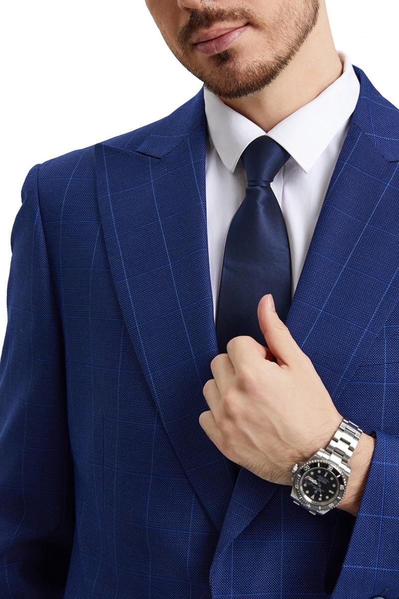 Stacy Adams men's suit: Blue windowpane plaid, peak lapel, textured fabric. Includes navy vest and tie. Silver watch. Structured fit for a sharp, sophisticated look.
