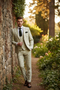 Light beige men's 3-piece suit with subtle check. Includes single-breasted jacket, 3-button waistcoat, and slim-fit trousers. Styled with white shirt & dark tie.