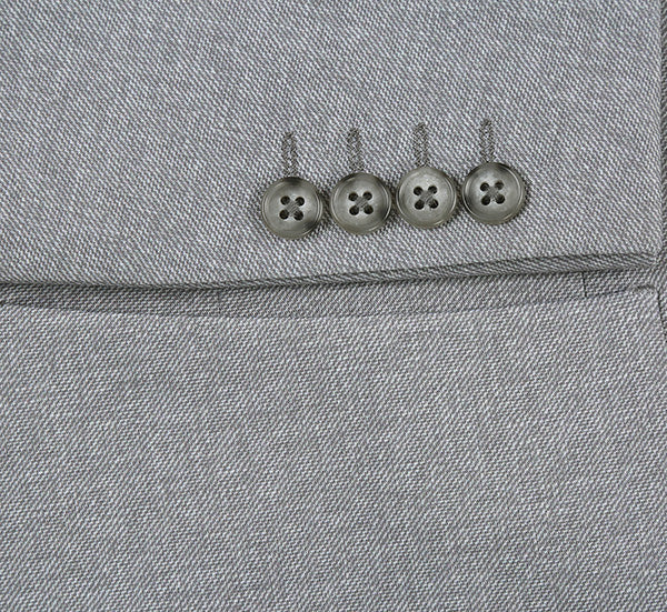 Gray, slim-fit blazer with textured herringbone fabric. Half canvas construction. Features metallic sleeve buttons and a chest pocket. A modern, tailored look.
