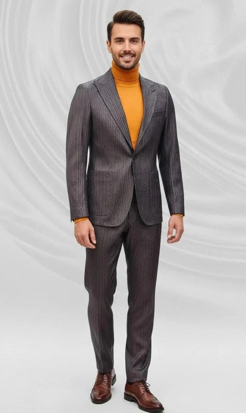 Dark brown, slim-fit men's suit with peak lapels and a pinstripe. Features a tailored structure, one button, and two front pockets. Paired with an orange turtleneck and brown shoes for contrast. Smooth, subtly shiny fabric.
