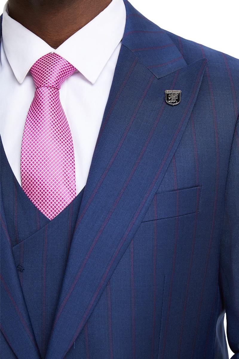 Navy Stacy Adams suit with a one-button design, peak lapels, and pinstripes. Features a textured fabric, left-side pocket, and lapel emblem. Worn with a white shirt and pink, grid-patterned tie.
