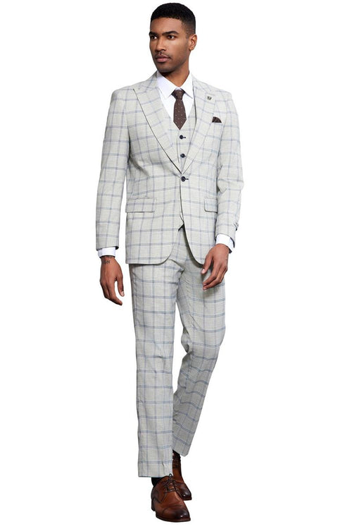 Men's Stacy Adams grey-blue windowpane plaid suit. Tailored fit, single-button, peak lapel, vested. Features a light grey fabric with a blue check pattern. Slim trousers, paired with brown dress shoes.
