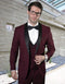 Burgundy wool one-button shawl tuxedo with black satin lapels & buttons. Includes a matching double-breasted vest, white dress shirt, and black bow tie. Fitted shape.
