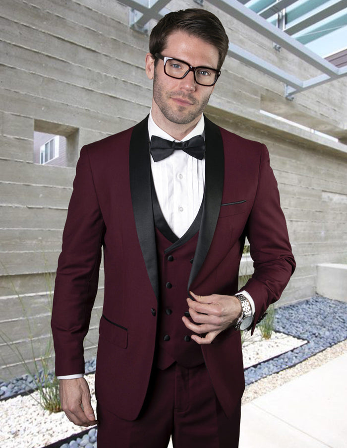 Burgundy wool one-button shawl tuxedo with black satin lapels & buttons. Includes a matching double-breasted vest, white dress shirt, and black bow tie. Fitted shape.
