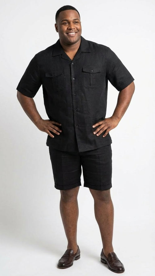 Men's black walking suit consisting of a short-sleeved button-up shirt and knee-length shorts. The shirt features a collared neckline with two front pockets. Both pieces are made of a lightweight, textured fabric, all in a solid black color.