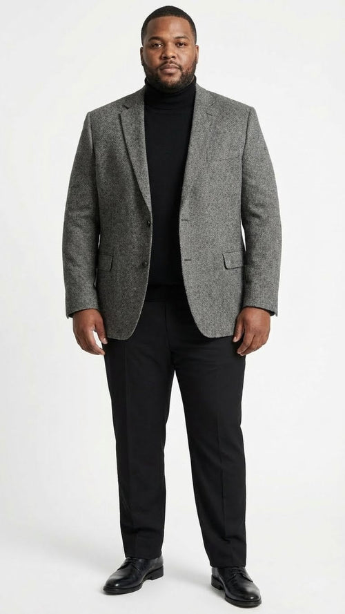 Men's grey tweed herringbone sport coat. Structured shape, notched lapel, two front pockets. Wool blend with textured herringbone pattern. Shown with black turtleneck for contrast.
