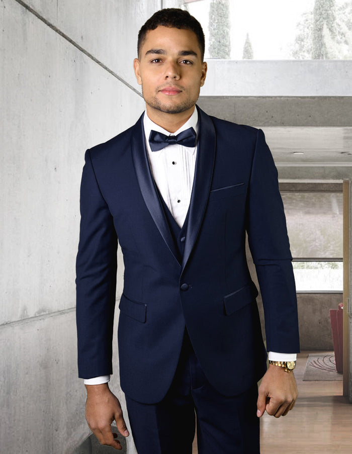 Navy wool tuxedo with modern fit. Features a shawl lapel, single-button closure, and side pockets. Tailored silhouette crafted from a wool blend. Sleek cuffs.
