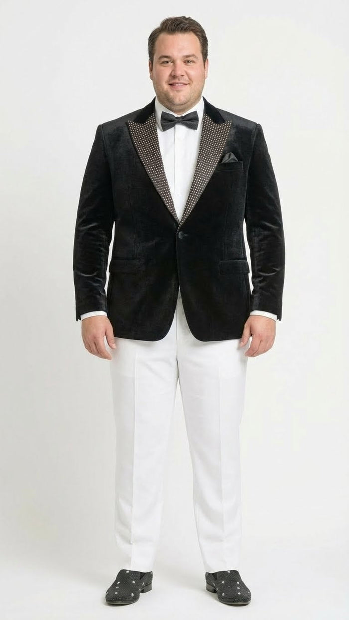 Black velvet tuxedo blazer. Fitted, deep black. Studded lapel contrasts the plush velvet. Classic style with two front pockets.

