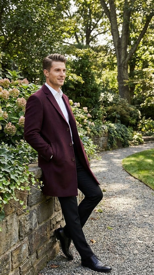Alberto Nardoni men's burgundy mid-length overcoat. Straight cut, structured shoulders, single-breasted with buttons. Textured fabric, side pockets, notched lapel. Mid-thigh length.
