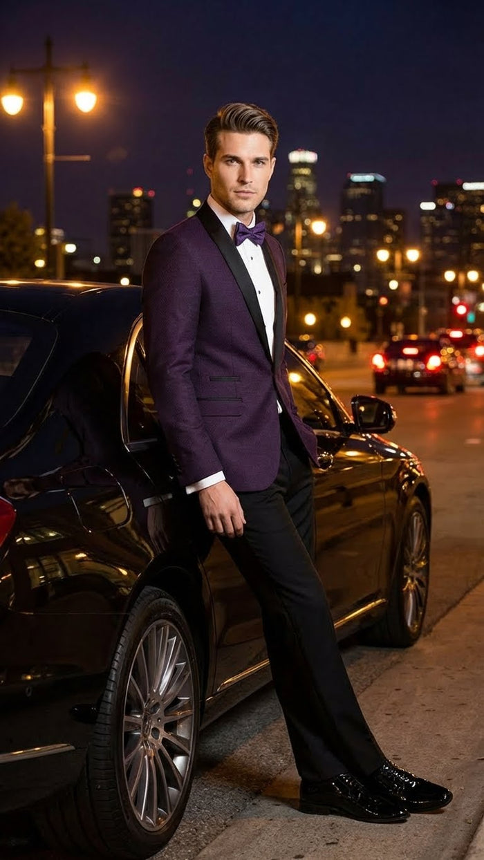 Eggplant purple tuxedo blazer with satin lapels. Fitted, single-button closure, two side pockets. Smooth, slightly textured fabric. Classic notch lapel, black accents. Deep purple hue.
