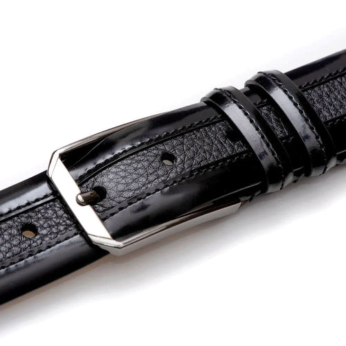 Black Mezlan deerskin belt. Smooth, shiny texture, flat rectangular shape. Soft leather with silver buckle. Evenly spaced holes, stitched edges, and loops to hold excess length.
