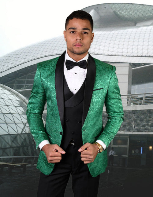 Emerald green paisley tuxedo with shawl lapel. Includes fitted vest. Shiny, textured fabric. Tailored jacket with structured shoulders, fitted sleeves. Features black waistcoat & bow tie accents.
