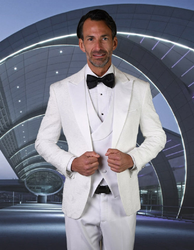 White paisley tuxedo for men. One-button closure, peak lapel. Textured fabric, matching vest and pants. Elegant, all-white formal wear.
