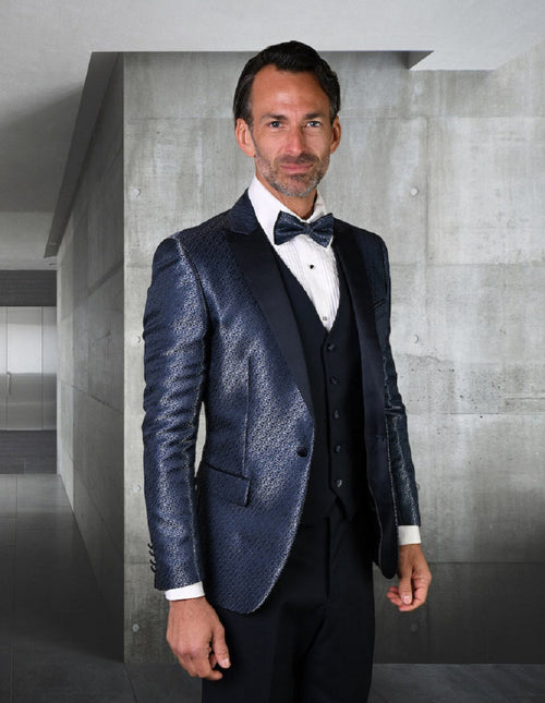 Navy peak lapel tuxedo with shiny pattern. Fitted design, structured shoulders, and tailored shape. Single-breasted vest with satin details. Formal aesthetic.
