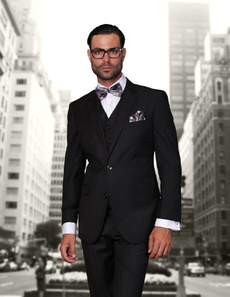 Black wool men's suit with a modern, fitted silhouette. Includes a vest, 2-button closure, and contrasting white cuffs. Accented with a pocket square.