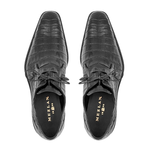 Mezlan Anderson men's shoes: Glossy black crocodile leather, pointed toe, structured design. Rectangular pattern, central laces, contrasting lining with gold accents, sturdy sole.
