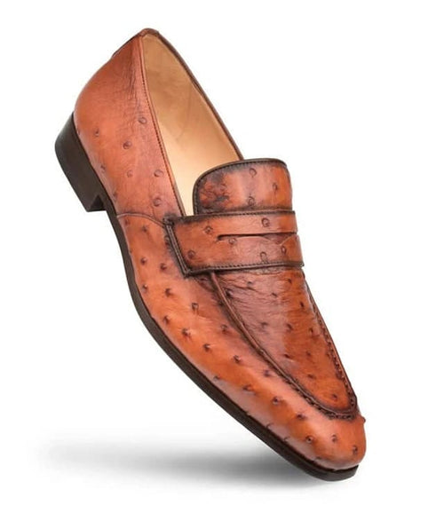Mezlan Lisbon slip-on loafer in brandy ostrich leather. Streamlined, rounded shape with a flat band. Features a textured pattern, pointed toe, raised heel, and smooth lining for an elegant look.
