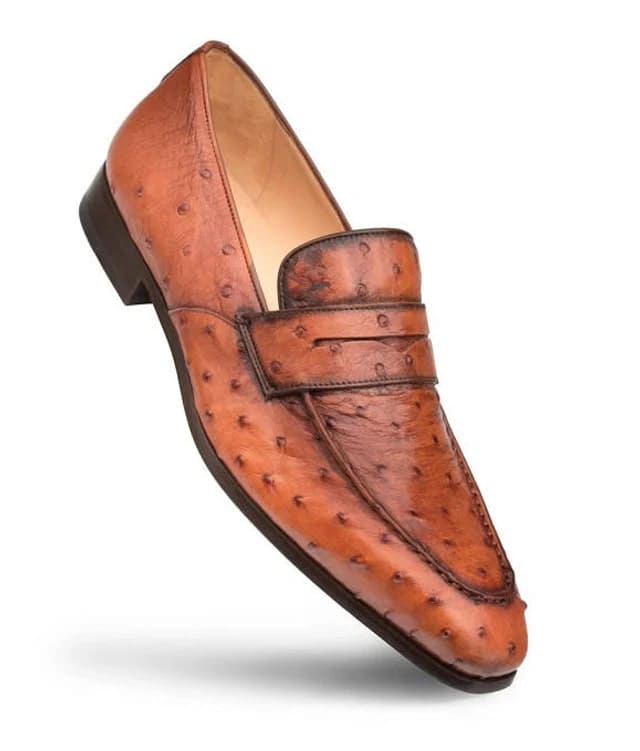 Mezlan Lisbon slip-on loafer in brandy ostrich leather. Streamlined, rounded shape with a flat band. Features a textured pattern, pointed toe, raised heel, and smooth lining for an elegant look.
