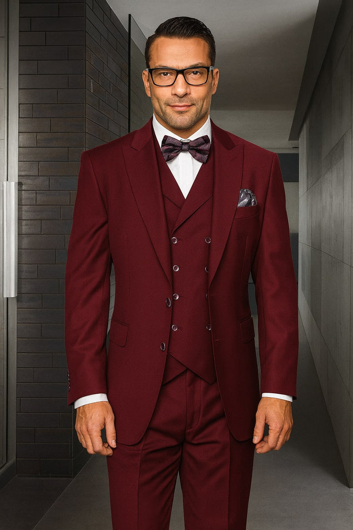 Men's urban suit in burgundy 100% wool. Features a single-button, double-breasted vest layered under a jacket, and pleated pants. Structured tailoring creates a uniform, sophisticated look.