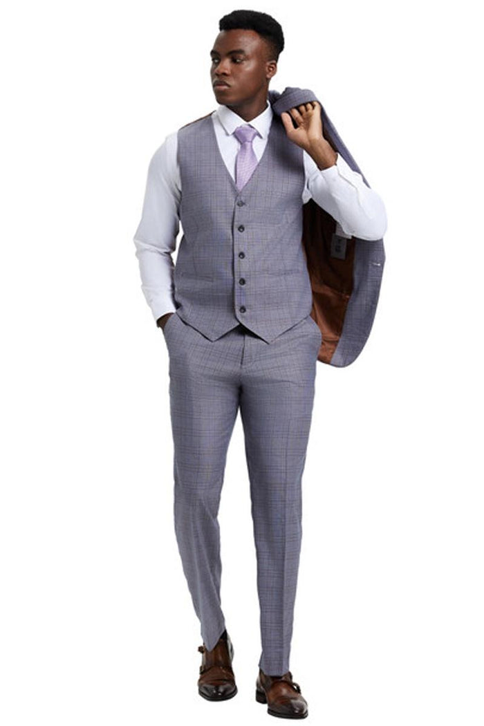 Stacy Adams men's one-button suit in light grey windowpane plaid. Features a single-breasted jacket with wide peak lapel, matching vest, and tailored trousers. Jacket has a contrasting brown lining.
