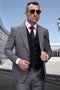 Men's black plaid wool suit with peak lapels. Includes a tailored jacket with structured shoulders, a black vest, matching trousers, white shirt, and polka dot tie. Two-toned gray pattern.
