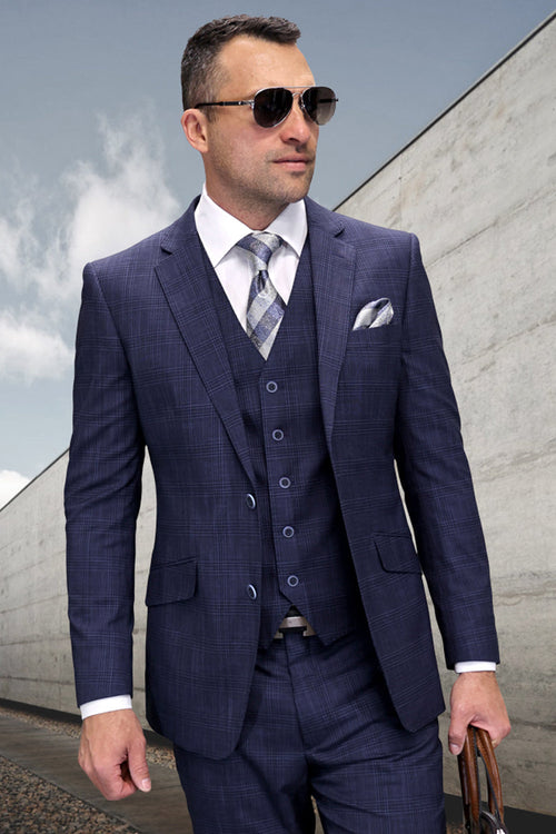 Navy blue modern fit men's suit. Designer wool sharkskin with a fitted jacket, notched lapel, and patterned vest. Matching trousers complete the look. Subtle sheen and textured pattern.
