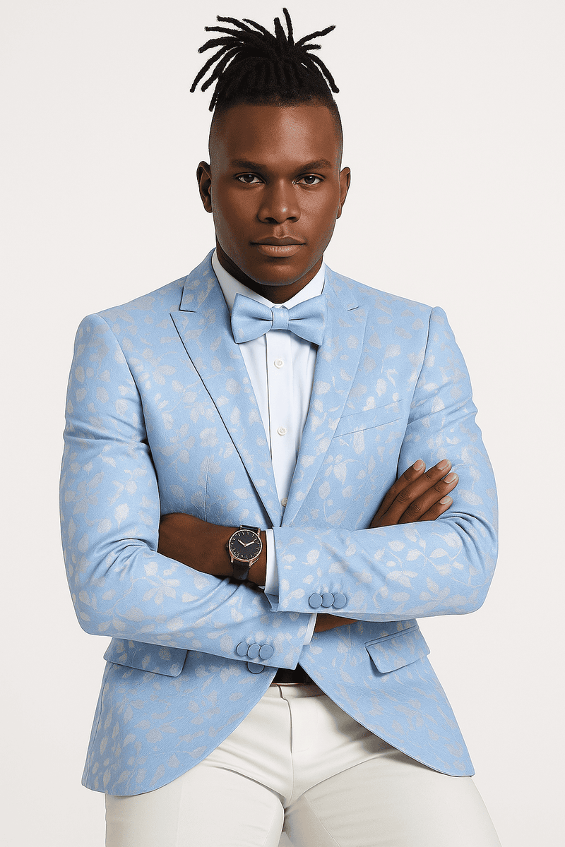 Men's slim fit sky blue tuxedo jacket with silver paisley foil print. Notched lapel, two buttons, front pockets, and cuff buttons. Worn with a light blue shirt and white trousers.
