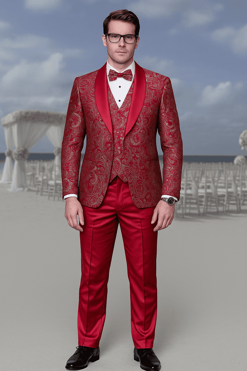 Red paisley brocade men's prom tuxedo: double-breasted vest suit, red paisley, matching trousers. Satin shawl lapel, white shirt, bow tie. Shiny black shoes. Structured fit, elegant design.
