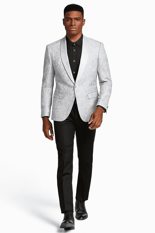 Silver grey tonal paisley tuxedo jacket. Structured with single-button closure, textured fabric, contrasting satin shawl lapel. Paired with black trousers. Subtly darker paisley accents.
