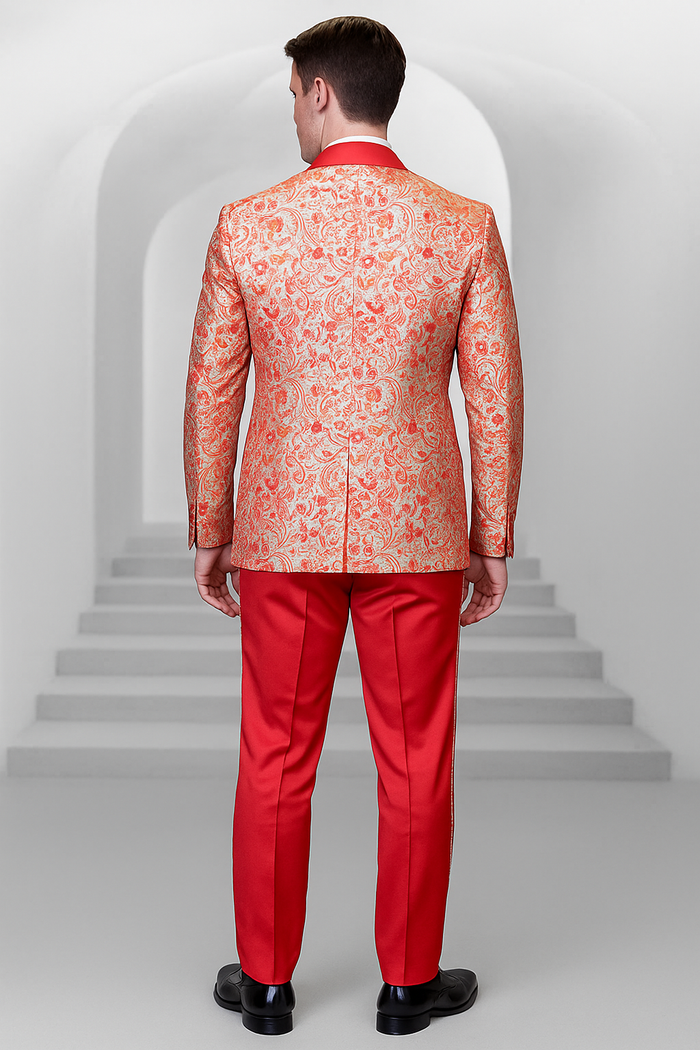 Coral orange men's shiny paisley wedding tuxedo. Intricate paisley patterns on the jacket with structured silhouette, back vent. Red trousers and solid red collar. Smooth, glossy materials for a formal design.
