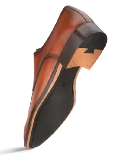 Mezlan Coventry oxfords: cognac calfskin, architectural design. Smooth leather upper, minimal detailing, black rubber sole with slight heel rise. Clean lines, classic style.
