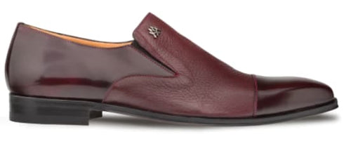Milani burgundy slip-on with elongated shape. Calfskin upper with subtle sheen, deerskin accents, rounded toe, and flat black sole. Embossed logo detail. Contrasting textures.
