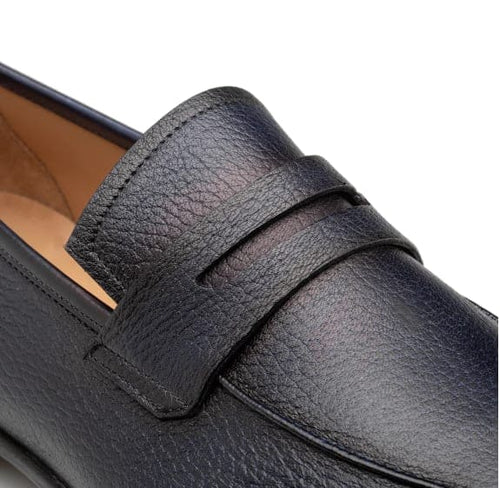 Men's blue deerskin penny loafers with a rounded toe. Textured blue deerskin upper, penny slot detail. Beige interior. Low profile.
