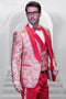 Coral orange paisley tuxedo: shiny finish, swirling floral jacket, solid vest, bow tie, and trousers. Shawl collar jacket with contrasting trim. Tailored fit, vibrant color, and intricate pattern.
