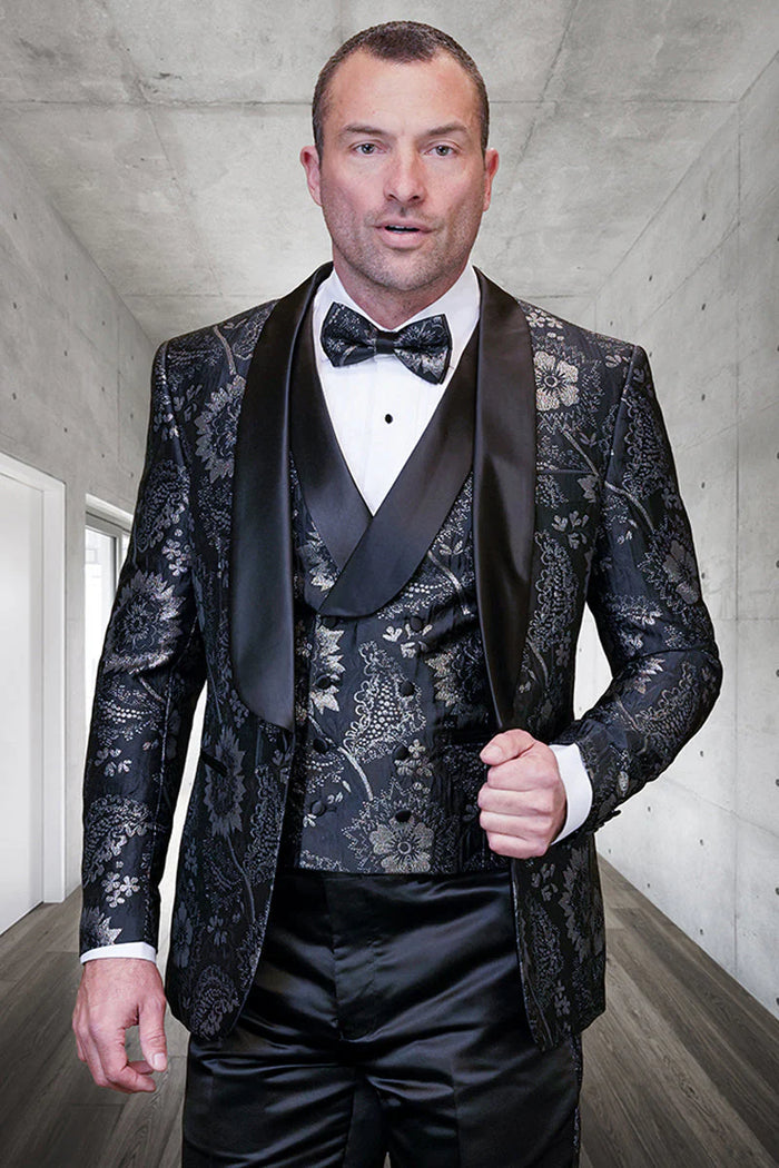 Alberto Nardoni's black paisley tuxedo: fitted, with a satin shawl collar. Features a matching vest & black satin trousers. Primarily black with silver accents, intricate floral detailing.

