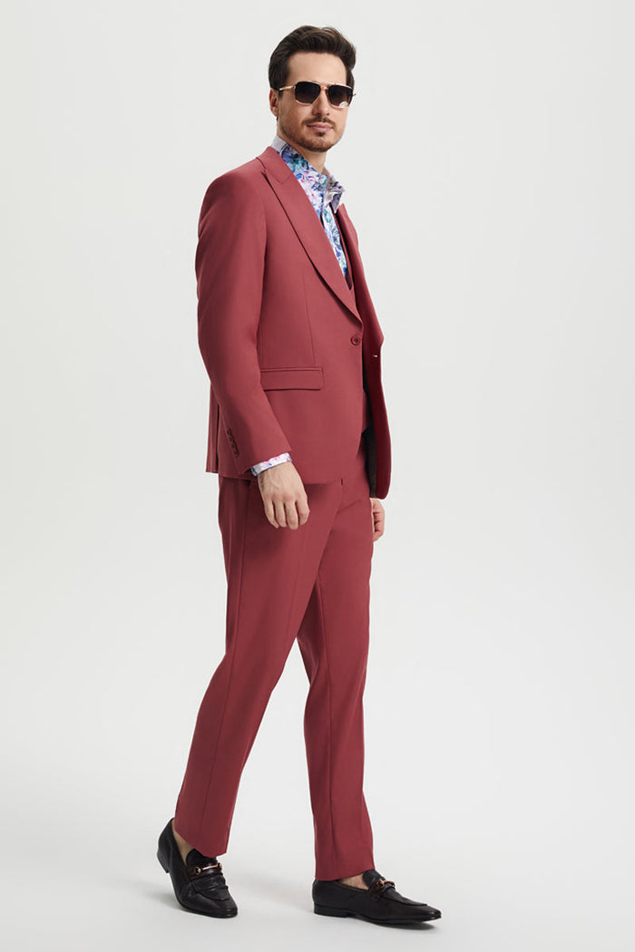 Coral blush pink Stacy Adams men's suit. Features a peak lapel, one-button closure, and fitted vest. Tailored cut with smooth fabric and matching slim-fit trousers. Designer quality.
